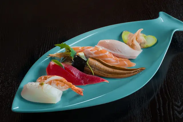 Assorted sashimi served on a teal fish-shaped plate