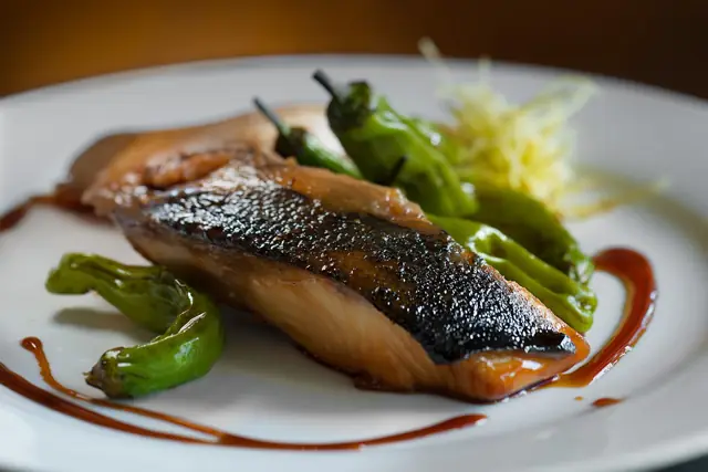 Grilled fish fillet with blistered shishito peppers