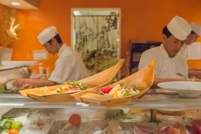 Sushi chefs arranging boat platters at the sushi bar