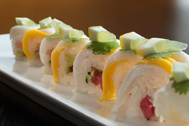 Specialty roll topped with mango and avocado slices