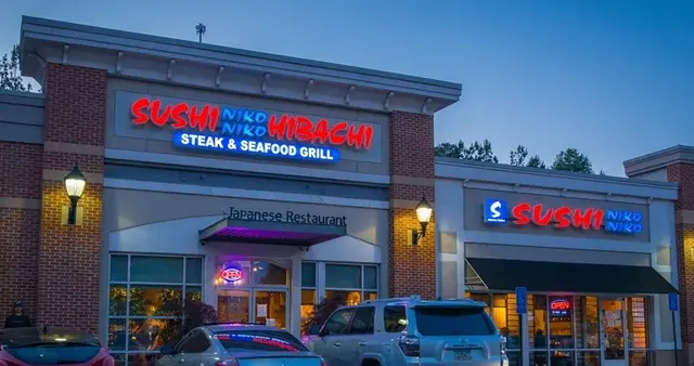 Sushi Niko Niko restaurant exterior at dusk with its lit sign above the entrance