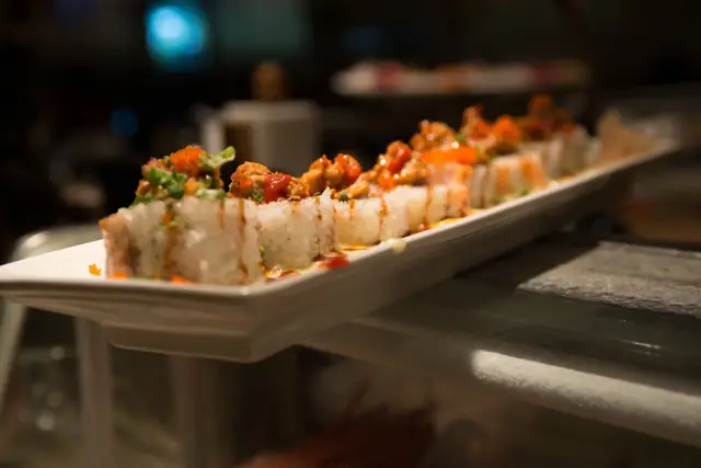 Long specialty roll platter displayed at the sushi bar