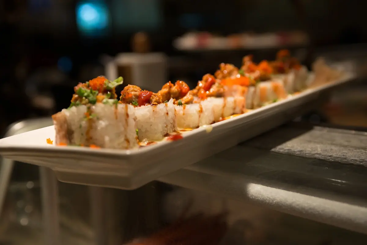 Long specialty roll platter displayed at the sushi bar
