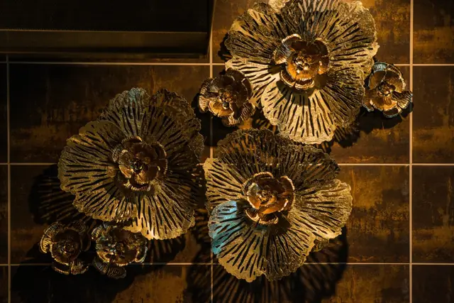 Decorative metal flower sculptures on a dark restaurant wall