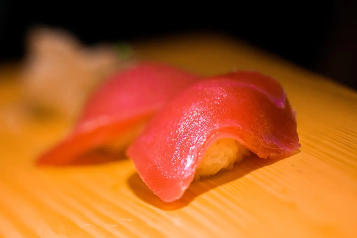 Two pieces of tuna nigiri on a wooden board